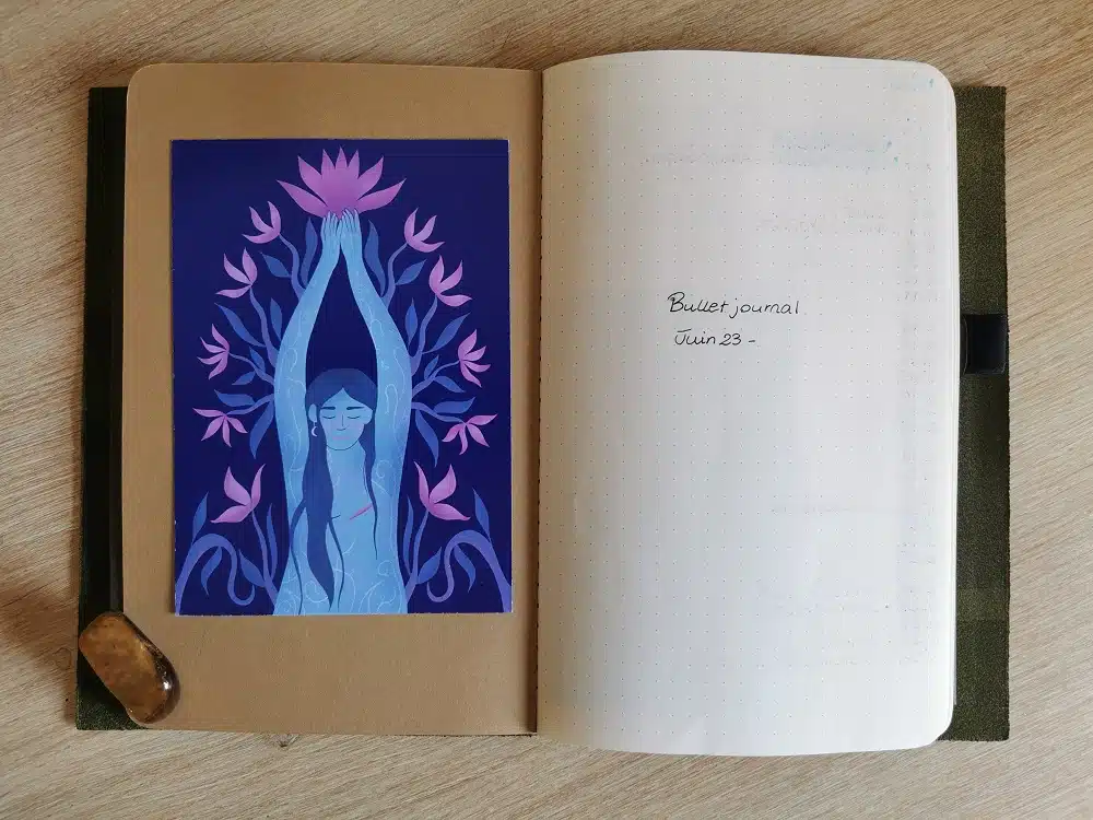 L'intérieur de la couverture de mon carnet Moleskine, sur laquelle j'ai collé une carte postale de l'artiste Amande Bleue.